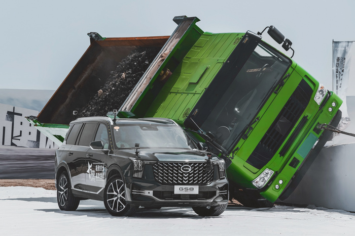 重載貨車在牽引車的牽引下通過單邊橋並接近側翻點,兩車越接近體積